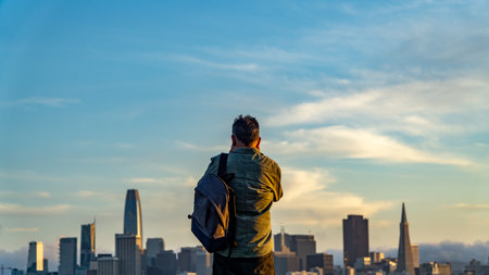 San Francisco, USA - August 2019: Man taking photo of san francisco bay during sunset