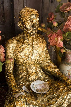 Buddha covered with gold leaf offerings at Wat Trai Mit in Bangkok, Thailand.の写真素材