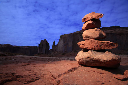 Dramatically lit zen-like tower of stones in Monument Valley.の写真素材