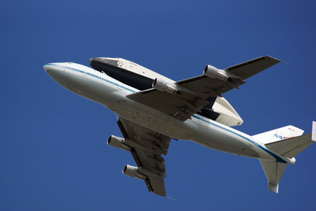 A space shuttle atop a flying 747 planeのeditorial素材