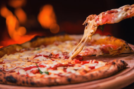 Taking tasty pizza out of oven in restaurant kitchenの写真素材