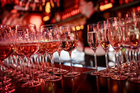 a row of sparkling wine glasses on the bar during a partyの写真素材