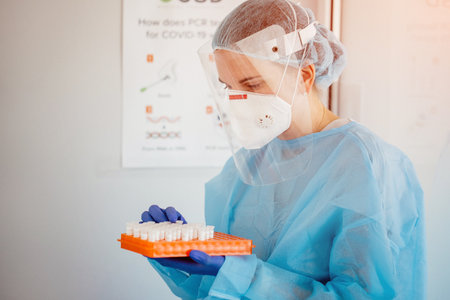 Woman doctor holding test tube with covid-19 coronavirus vaccineの写真素材