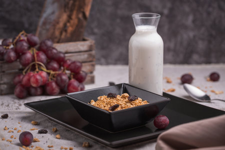 healthy breakfast oatmeal with granola and raisins in a bowl and yogurt with chiaの写真素材