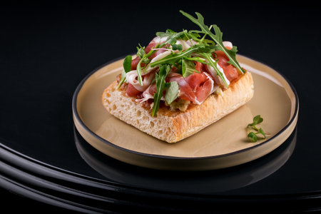 delicious crispy bruschetta with chopped pieces of jamon and arugula leavesの写真素材