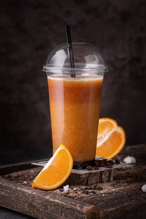 fresh orange juice in takeaway plastic cup with fresh orange slicesの写真素材