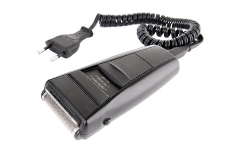 The black electrorazor with a cord and a plug on a white background, closeup, isolatedの写真素材