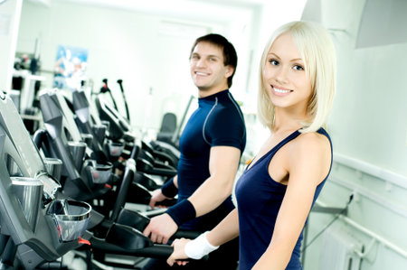happy cutie athletic girl and guy, execute exercise on running track and smile, in sport-hall happy cutie athletic girl and guy, execute exercise on running track and smile, in sport-hall
