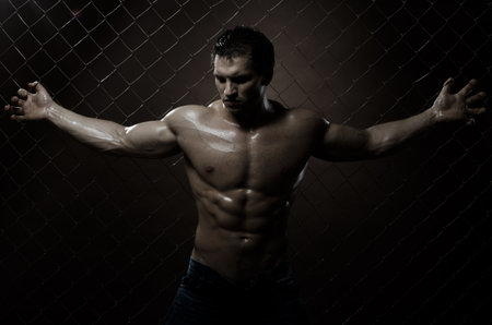 the very muscular handsome sexy guy ,  on  netting   steel fenceの写真素材