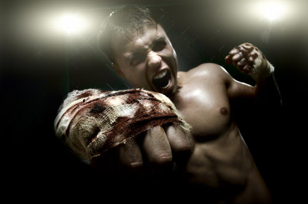 horizontal photo  muscular young  guy street-fighter, cuff  fist close up on camera and yell , hard lightの写真素材