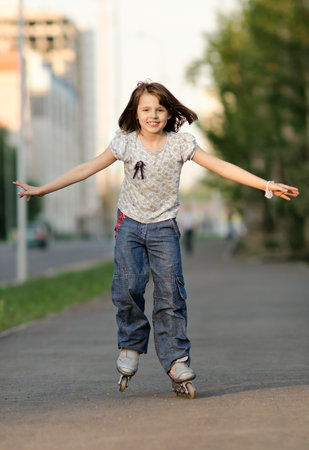 little young girl go on  roller skates, outdoor, in the evening summerの写真素材