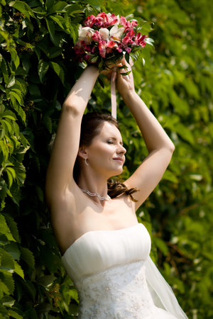 vertical wedding portrait beautiful  fiancee with  bouquet  in white dressの写真素材