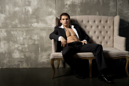 the very muscular handsome sexy guy in black  suit indoorの写真素材