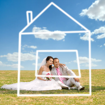 beautiful newly married couple  on nature in park , sit on  lawn and dreaming about houseの写真素材