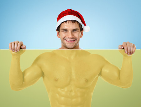 fitness sexy Santa Claus , stand with yellow banner and smileの写真素材