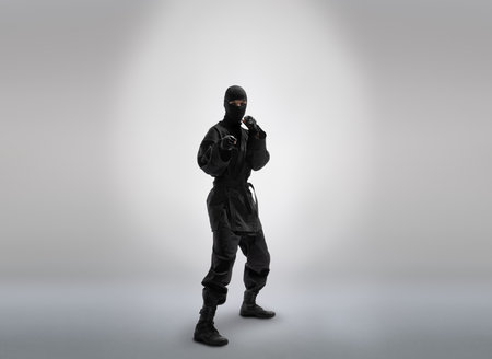 one japanese ninja in black uniform, on gray backgroundの写真素材