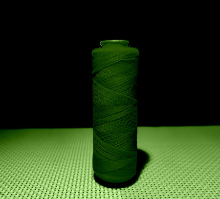 Green color sewing thread with dark background.の写真素材