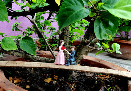 Innovative showpiece image of cute boy and girl on flower pot.の写真素材