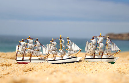 Sea composition: funny small toy sailing ships on the beach の写真素材