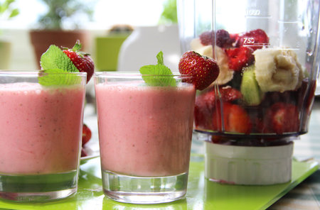 Smoothies and fresh fruits on the tableの写真素材