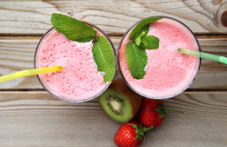 Smoothies and fresh fruits on the tableの写真素材