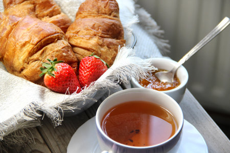 Fresh French croissant and strawberries on the table