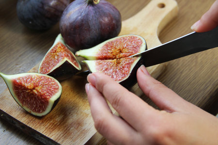 Beautiful ripe fresh pulpy figs on the wooden tableの写真素材