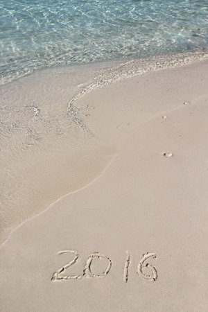 Handwriting inscription 2016 on the beach with clean blue waterの写真素材