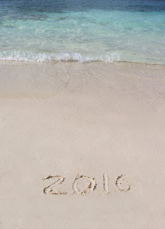 Handwriting inscription 2016 on the beach with clean blue waterの写真素材