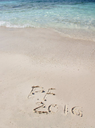 Handwriting inscription 2016 on the beach with clean blue waterの写真素材