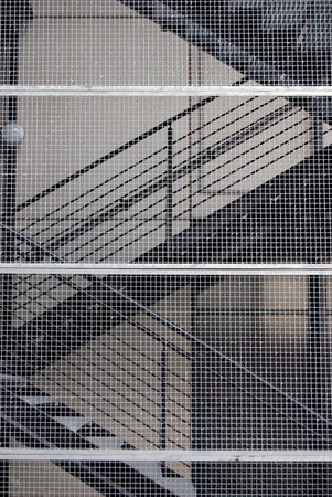 Metallic stairs of the office building behind netの写真素材