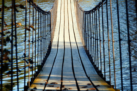 Wooden suspension bridge hanging over the riverの写真素材