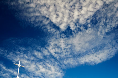 White cross in the blue cloudy skyの写真素材