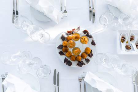 Snacks platter served on a white table, flat lay. Top view on restaurant table with assortment of meat side dishes, free space. Buffet, banquet, menu conceptの写真素材