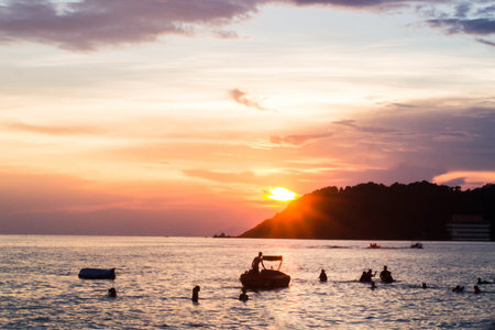 People swimming into the sea with twilight sky.の写真素材