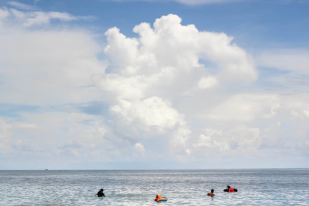Family into the sea with big clouds on blue sky.の写真素材