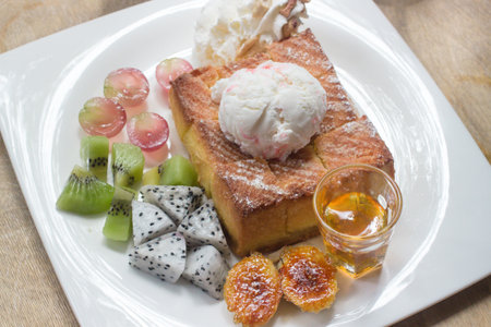 Honey toast on white dish with  banana, kivi, grape and icecream.の写真素材