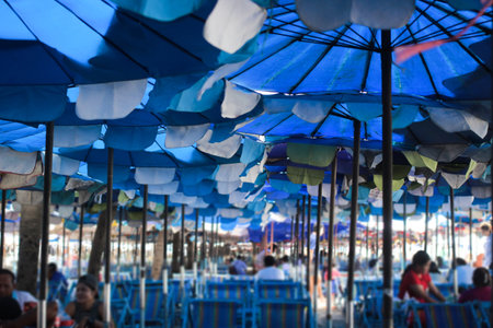 People sitting on chair for relaxing and eating  under umbrella beach beside sea shore.の写真素材