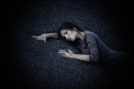 Beautiful sad girl on a mound of coalの写真素材