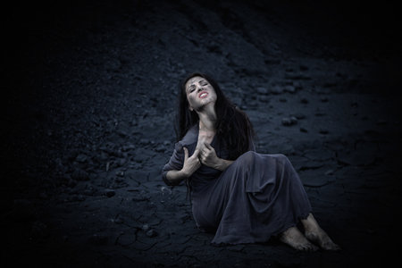 Beautiful sad girl on a mound of coalの写真素材