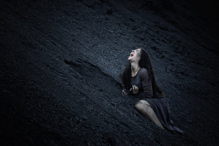 Beautiful sad girl on a mound of coalの写真素材