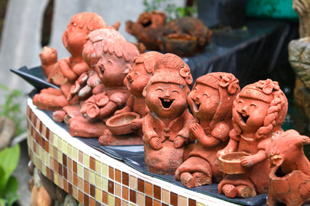 Thai children laughing clay doll for house decorationの写真素材