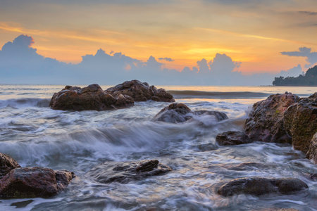 Morning scenery with beautiful skies on the coast with waves lapping against the rocks