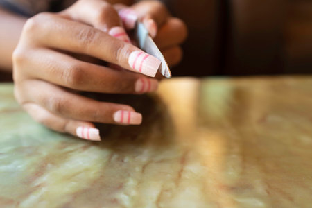 A close-up shot of using a small file to trim a woman's manicure.の写真素材
