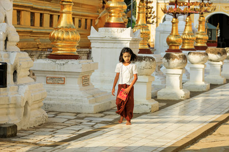 Bagan/Myanmar-October 4th 2019: A Burmese girl is walking on a sidewalk decorated with Burmese sculpture in a temple.のeditorial素材