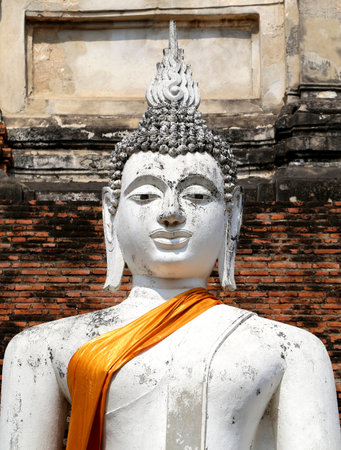 lovely white statue of Buddha on a background of an old wallの写真素材