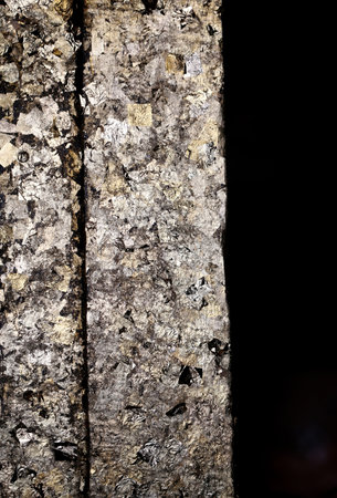 macro ancient wall with gold on a black background の写真素材