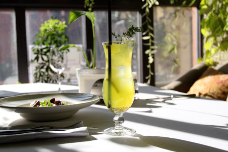 Macro photo of a delicious cocktail with thyme lit by the sun in a restaurantの写真素材