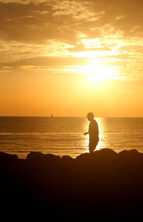 Photo of sea sunset beautiful landscape with a boy and the sunの写真素材