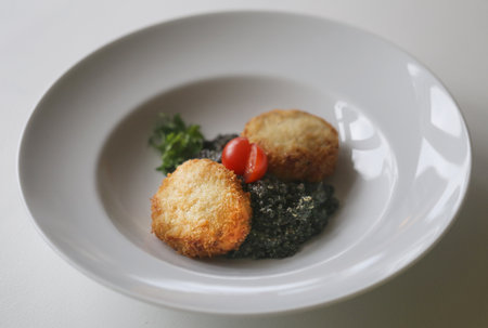 Delicious bright macro photo of fish cutlets with quinoa in a restaurantの写真素材